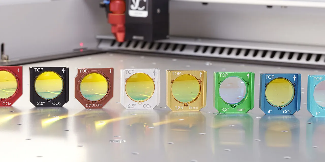 Lentilles laser Trotec pour découpe laser CO₂ et à fibres disposées par longueur focale sur le banc de la machine.